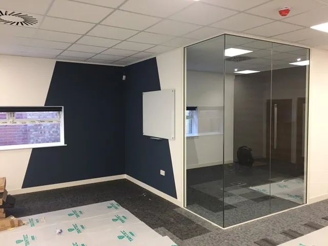 Commercial office with a dark painted feature wall and glass partition in Bournemouth