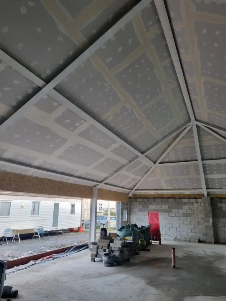 Interior construction progressing with insulated ceiling and blockwork walls.
